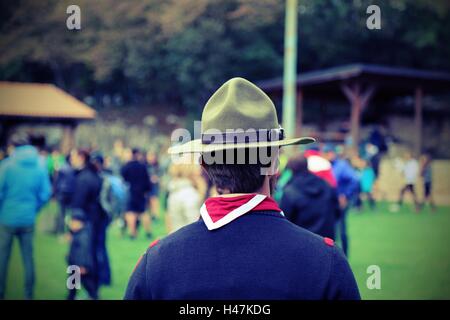 Chef scout à la réunion de jeunes gens en uniforme avec bonnet et écharpe rouge et blanc Banque D'Images