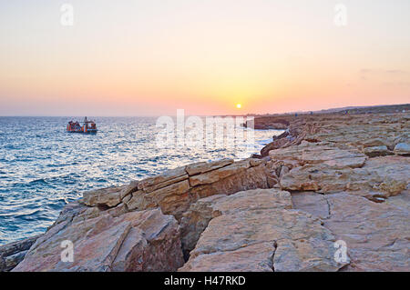 Le yacht navigue le long du littoral de la baie de Famagouste et profiter du coucher du soleil à Ayia Napa, Chypre. Banque D'Images