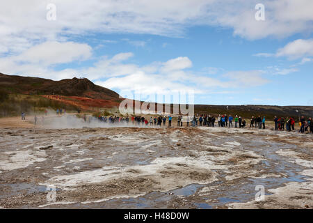 Les touristes restent là à attendre le strokkur geysir geyser en éruption en Islande Banque D'Images