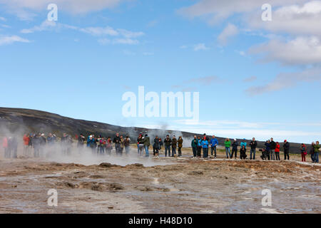 Les touristes restent là à attendre le strokkur geysir geyser en éruption en Islande Banque D'Images