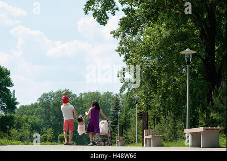 Famille heureuse de quatre personnes marchant dans la ville parc Banque D'Images