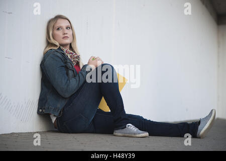 Jeune femme triste assis sur le plancher, Banque D'Images
