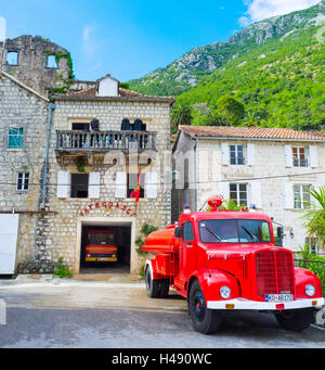 Le poste d'incendie, situé dans la vieille maison sur la promenade de la ville, avec le camion rouge à côté, Perast Banque D'Images