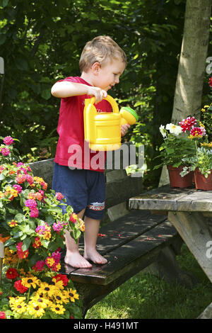 Petit enfant, garçon sur banc de jardin en fonte avec la fleur, Banque D'Images