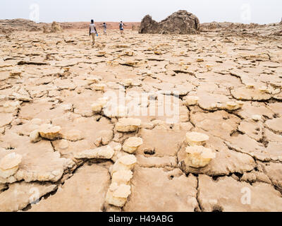 Les gens marcher à travers les formations du sol minéral autour du lac de soufre dépression Danakil, Dallol, l'Éthiopie, le meilleur endroit sur Terre. Banque D'Images