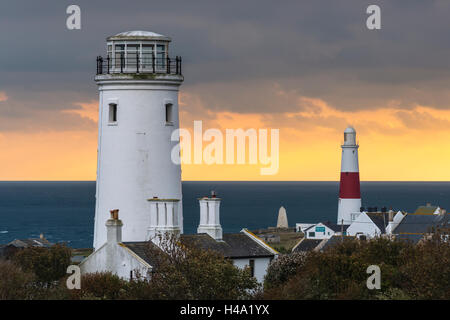 Portland Bill, Dorset, UK. 14 octobre 2016. Météo britannique. Fiery orange glow dans le ciel vers la mer à l'horizon en fin d'après-midi que les nuages s'épaissir au-dessus de l'ancien phare inférieur et le nouveau phare de Portland Bill dans le Dorset. Le vieux phare inférieur est maintenant utilisé un observatoire d'oiseaux et est un bon endroit pour voir les oiseaux migrateurs rares. Photo : Graham Hunt/Alamy Live News Banque D'Images