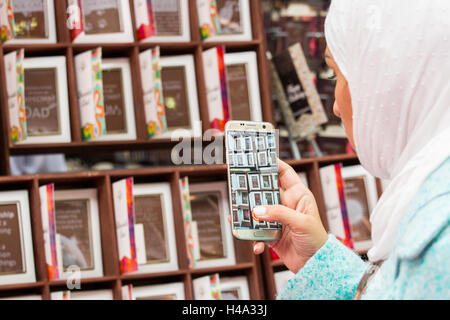 Londres, Royaume-Uni. 14-10- Femme avec voile prend des photos de cartes de Noël faites de chocolat. Au salon du chocolat qui se déroule à l'Olympia de Londres, au Royaume-Uni du 14ème-16ème Octobre 2016, comme la grande finale de chocolat 7. © Laura De Meo/Alamy Live News Crédit : Laura De Meo/Alamy Live News Banque D'Images