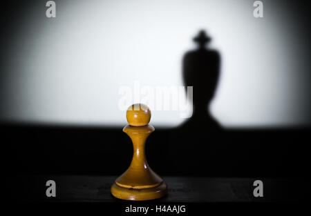 Un pion d'échecs d'une pièce sombre dans l'ombre du roi de force et d'aspirations concept Banque D'Images