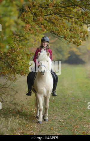 Les adolescents, de fille, de chevaux Islandais, meadow, ride, head-on, voir l'appareil photo, Banque D'Images