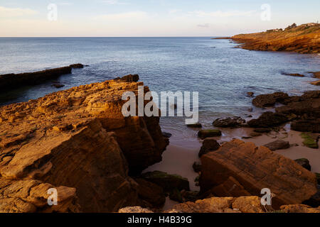Le lever du soleil sur la côte de roches dans l'Atlantique à Luz, à l'ouest de Lagos, Algarve, Portugal, Europe Banque D'Images