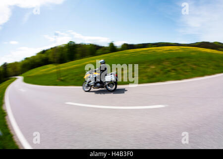 Germany, Bavaria, un motocycliste sur route de campagne au printemps Banque D'Images