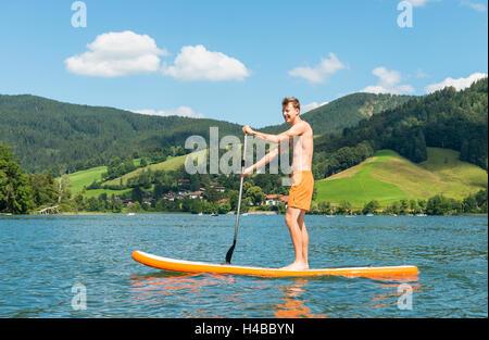 Jeune homme sur un paddle board, lac Schliersee, Haute-Bavière, Bavière, Allemagne Banque D'Images