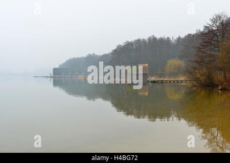 Les hangars à bateaux sur le lac dans la brume du matin, Aussensee Schweriner, Schwerin, Bade-Wurtemberg, Allemagne Banque D'Images