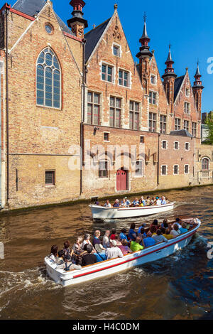 BRUGES, BELGIQUE - 6 avril 2008 : les touristes flottent sur un bateau à travers le canal près de gîtes Dijver Banque D'Images