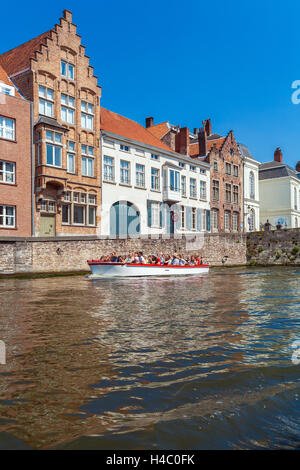 BRUGES, BELGIQUE - 6 avril 2008 : les touristes flottent sur un bateau à travers le canal près de gîtes Dijver Banque D'Images