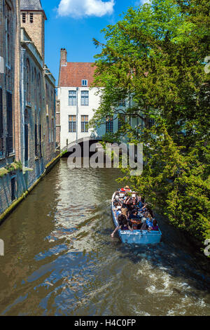 BRUGES, BELGIQUE - 6 avril 2008 : les touristes flottent sur un bateau à travers le canal près de gîtes Dijver Banque D'Images