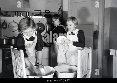 Vierlinge von Brücken der Zwei helfen ihrer Mutter bei der Hausarbeit, Deutsches Reich 1930er Jahre. Deux des quadruplets de Brücken aider leur mère, Allemagne 1930 Banque D'Images