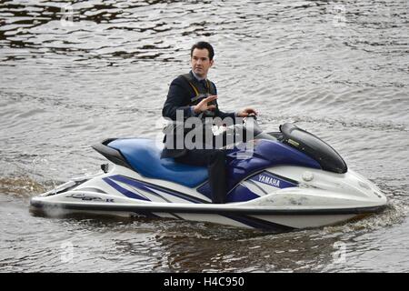 Le comédien Jimmy Carr rides un jet ski à Whitby Harbour comme Jeremy Clarkson's nouveau spectacle Le Grand Tour des films dans la ville balnéaire. Banque D'Images