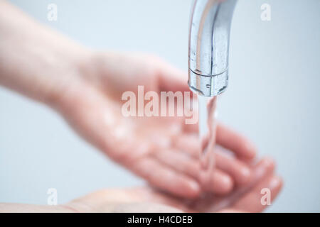 L'eau s'écoule à partir de puiser dans les mains Banque D'Images