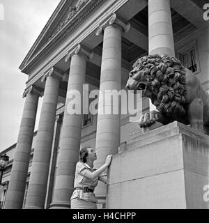 Eine Frau vor der Löwenstatue am Eingang von Schloss Rosenstein à Bad Cannstatt bei Stuttgart, Deutschland 1930er Jahre. Une femme en face d'un lion sculpture à l'entrée du château Rosenstein à Bad Cannstatt près de Stuttgart, Allemagne 1930. Banque D'Images