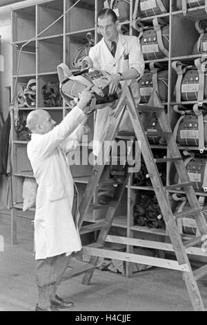 Des Gurtzeugs Fallschirms Auswahl von einer dans Fallschirm Näherei, 1940er Jahre Deutschland. En tenant le faisceau d'un parachute à un parachute de l'usine de couture, l'Allemagne des années 40. Banque D'Images