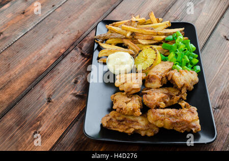 Poisson-frites avec mayonnaise maison sur la plaque noire Banque D'Images