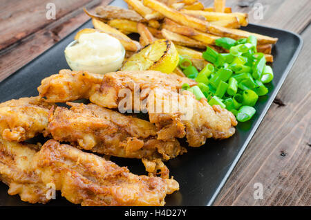 Poisson-frites avec mayonnaise maison sur la plaque noire Banque D'Images