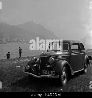 Ein Ford Eifel am Rhein mit dem Drachenfels im Hintergrund, Deutschland 1930 er Jahre. Un modèle Ford Eifel sur la rive du Rhin, avec en toile de fond la montagne Drachenfels, Allemagne 1930. Banque D'Images