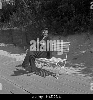 Ein alter Fischer sitzt auf einer Bank bei der Pillkallen Kurischen dans Nehrung Ostpreußen, Deutschland 1930er Jahre. Un vieux pêcheur assis sur un banc près de Pillkallen Courlande à Split dans l'Est de la Prusse, l'Allemagne des années 1930. Banque D'Images