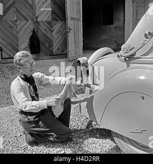 Der Fotograf Karl Heinrich Lämmel beim Wagenwaschen, Deutschland 1930 er Jahre. Le photographe Karl Heinrich Laemmel faisant le lavage de voiture, Allemagne 1930. Banque D'Images