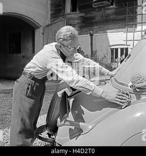 Der Fotograf Karl Heinrich Lämmel beim Wagenwaschen, Deutschland 1930 er Jahre. Le photographe Karl Heinrich Laemmel faisant le lavage de voiture, Allemagne 1930. Banque D'Images