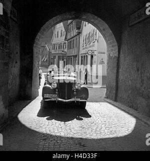 Mit dem Opel Olympia durch eine Unterführung à Schnait, Deutschland 1930 er Jahre. Avec un modèle Opel Olympia par un passage sous terre à Schnait, Allemagne 1930. Banque D'Images