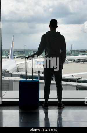 Un adolescent est en attente sur un aéroport pour départ Banque D'Images