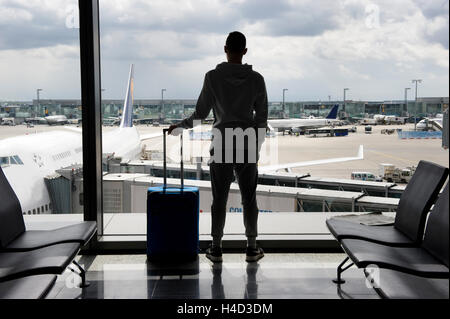 Un adolescent est en attente sur un aéroport pour départ Banque D'Images