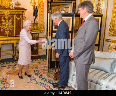 La reine Elizabeth II rencontre le président du conseil d'administration de la Croix-Rouge David Bernstein (centre) et de la Croix Rouge Chef de la Michael Adamson (à droite), à l'occasion du dévoilement d'un portrait de Sa par l'artiste anglais Henry Ward, marquant six décennies de patronage à la Croix-Rouge britannique, qui a été dévoilé au château de Windsor dans le Berkshire. Banque D'Images