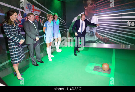 La duchesse de Cambridge (à gauche) observe que le duc de Cambridge prend une place-kick dans un jeu de tirs au but lors de leur visite à la Musée National du football de Manchester. Banque D'Images