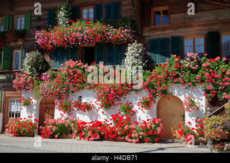 Vieux Simmentaler ferme avec décoration florale, près du ruisseau de l'aulne dans le Simmental, l'Oberland Bernois, Suisse Banque D'Images