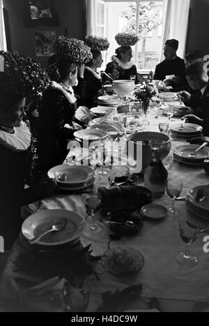 Eine Festtafel Bräuten gekleidet mit der jungen dans l schwarzwälder Tracht mit dem Bräutigamen Schäppel und ihren, Deutschland 1930 er Jahre. Un banquet avec les jeunes épouses de porter le costume traditionnel de la Forêt Noire avec l'Schäppel et l Banque D'Images