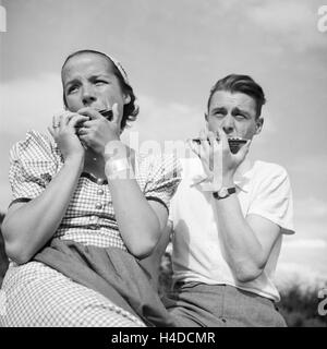 Ein Mann und eine Frau spielen Mundharmonika, Deutschland 1930 er Jahre. Un homme et une femme jouant de l'harmonica, Allemagne 1930. Banque D'Images