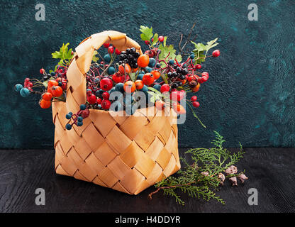 Panier en osier avec les baies sauvages sur texture background with copy space Banque D'Images