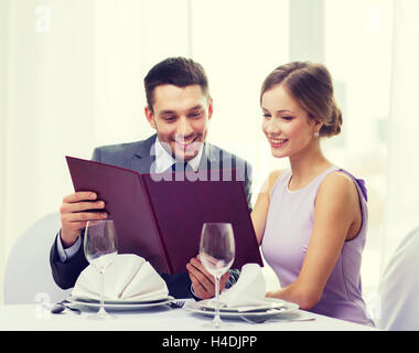 Smiling couple avec menu au restaurant Banque D'Images