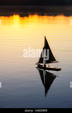 Old vintage sur un yacht de bassin lac encore au lever du soleil. Silhouette. UK Banque D'Images