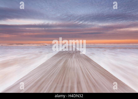 La ruée vers l'eau de mer à marée haute, les vagues déborder sur la jetée en béton à Blyth Beach, Northumberland Banque D'Images