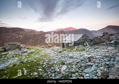 Dubs Hut et carrière située sur le côté de Fleetwith Pike surplombant les meules au lever du soleil et de la lune, les montagnes de Lake District Banque D'Images