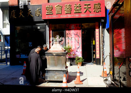 Les moines bouddhistes, l'argent de papier pour gravure joss est mort après une cérémonie à l'extérieur d'un temple à New York Chinatown.New York City, USA Banque D'Images