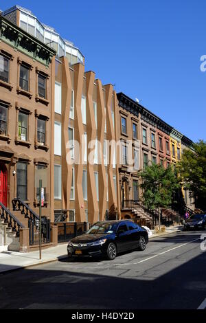 Une maison nouvellement construite entre les immeubles brownstone classique rénové.Harlem,.Manhattan New York City, USA Banque D'Images