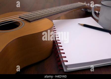 Tasse à café guitare Ukulele cahier et crayon sur table en bois close up Banque D'Images