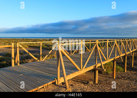 Passerelle en bois pour piétons près de la plage de Morro Jable phare dans le coucher du soleil, la lumière chaude de l'île de Fuerteventura, Espagne Banque D'Images