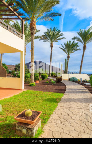 Appartements de vacances dans un jardin tropical le long d'une promenade dans la ville de Morro del Jable, Fuerteventura Island, Espagne Banque D'Images