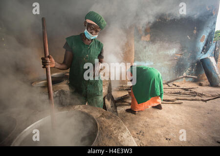 Les processus d'un employé dans l'huile de beurre de karité du commerce équitable à un site de production à réo, Burkina Faso, Afrique de l'Ouest. Banque D'Images